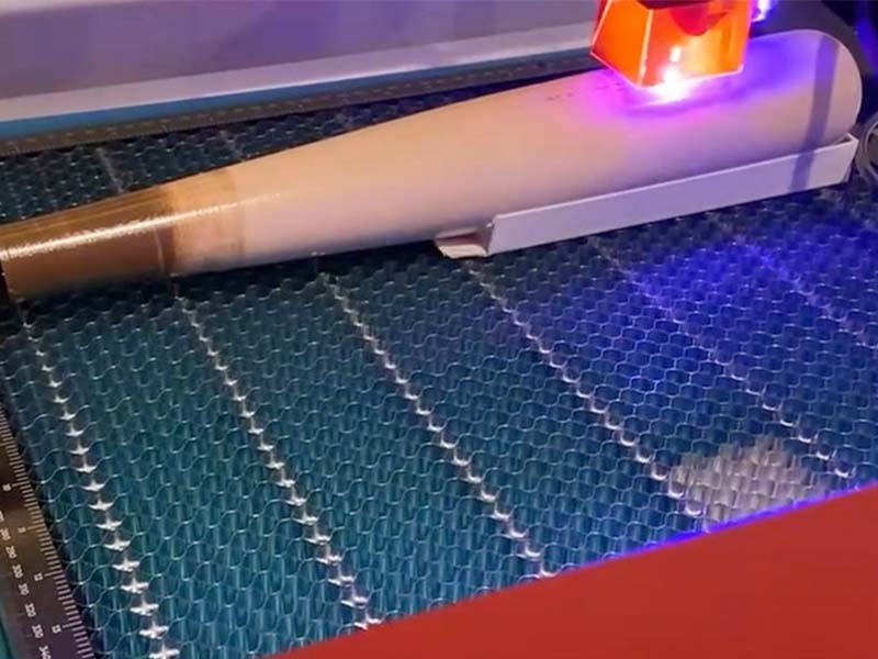 Razorbill Bats being engraved with precision using a laser engraver, showcasing the custom branding and detailed design on the barrel of each bat.