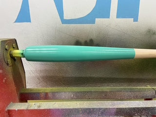 Razorbill Torpedo Bat on the lathe during custom painting process, showcasing handcrafted detailing and premium wood bat craftsmanship