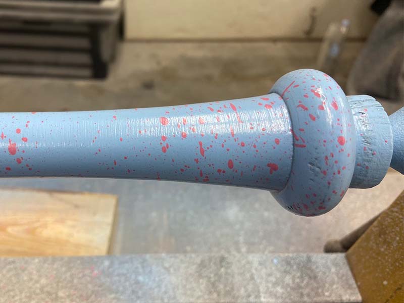 Razorbill bat featuring a speckled knob in the process of being crafted on a lathe, showcasing the attention to detail and precision in bat manufacturing.