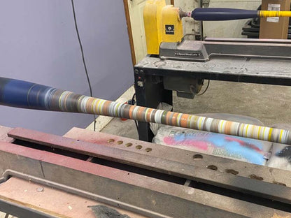 A spinning Razorbill bat featuring multiple colorful stripes along the barrel, creating a dynamic visual effect that highlights motion and custom design.