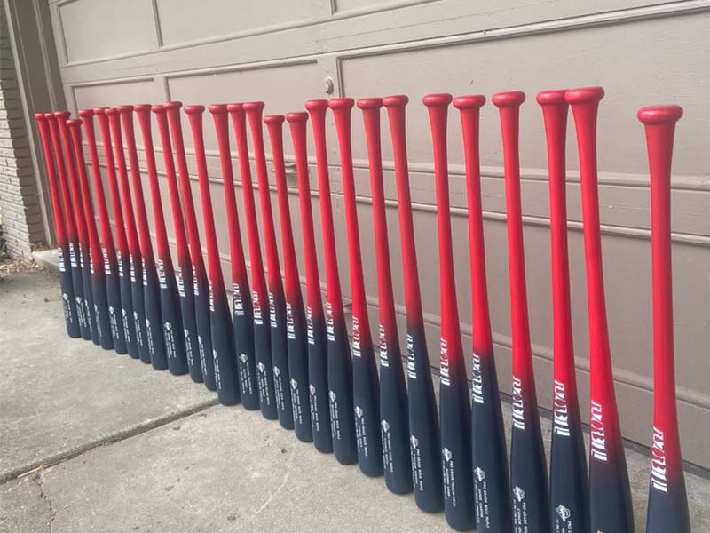 A lineup of custom Razorbill trophy bats arranged for a baseball team, each featuring engraved details to commemorate individual players and team achievements.