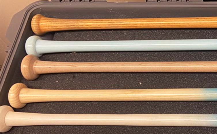 Close-up of wood grain handles on Razorbill fungo bats, showcasing the natural texture and premium craftsmanship for coaches seeking durability and style in training tools.